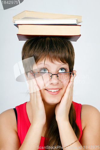 Image of girl in glasses with books on head