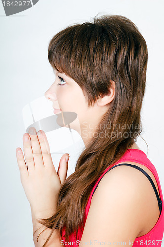 Image of blue-eyed teen girl praying. profile