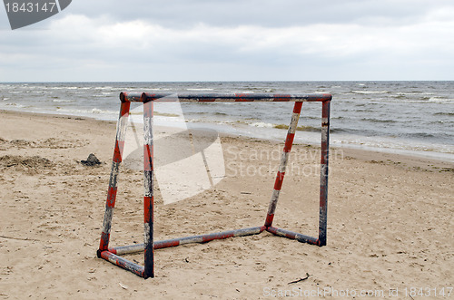 Image of Steel metal football goal gate on sea sand 
