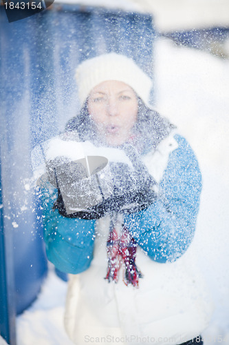 Image of Woman blowing snow