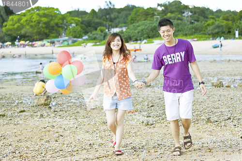 Image of Happy asian couple at beach