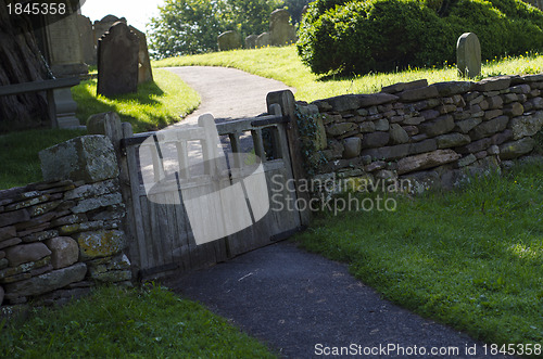 Image of Old wooden double gate in dry stone wall to churchyard