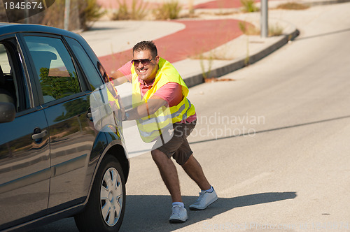 Image of Pushing his car