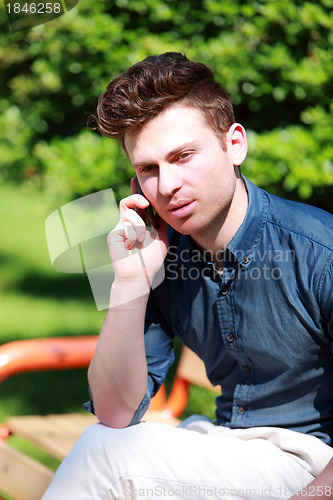 Image of Young man at telephone in nature