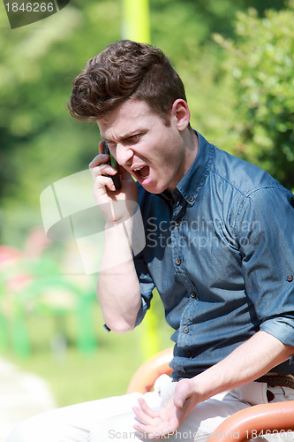 Image of Young man angry on telephone