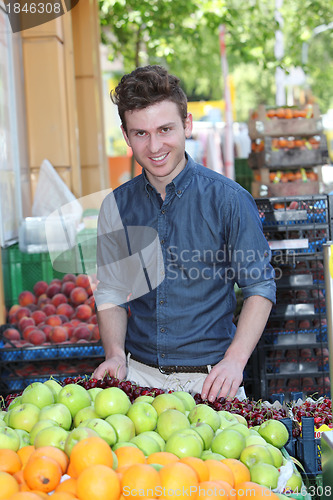 Image of Smiling customer buying fruits at grocery