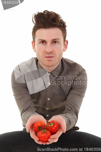 Image of Young man offering tomatoes