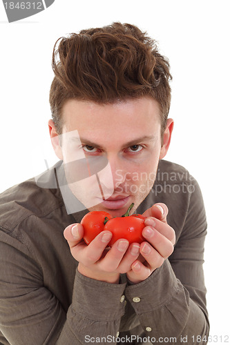 Image of Young man smelling tomatoes