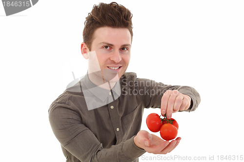 Image of Young man smiling with tomatoes