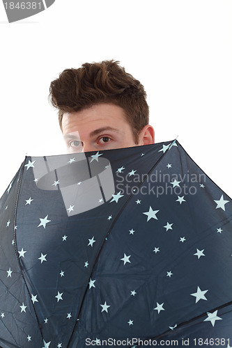 Image of Handsome man looking from umbrella