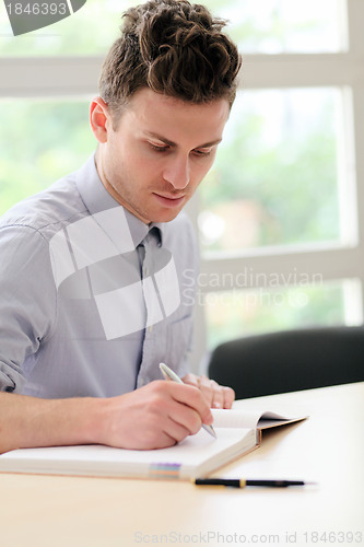 Image of Young adult man writing note