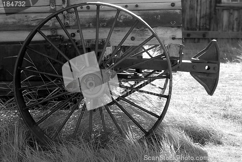 Image of Black and White image of an old weathered wagon with rusted whee