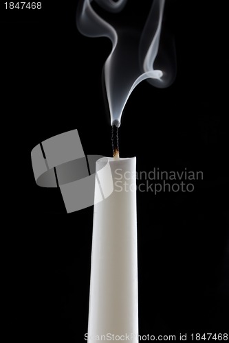 Image of extinguished candle with smoke, isolated over black
