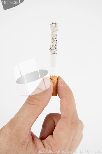 Image of Hand, holding burning cigarette on white background