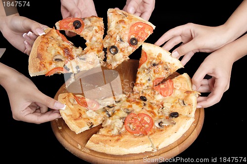 Image of A group of people taking slices of pizza