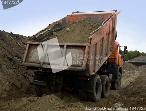 Image of A dump truck is dumping gravel 