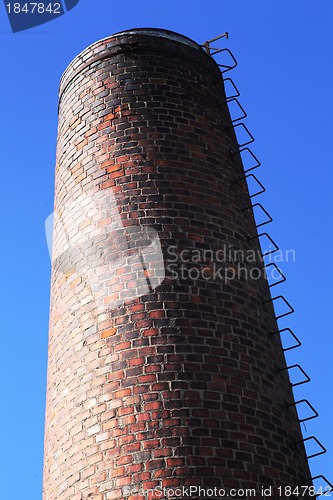 Image of old brick chimney on blue sky 