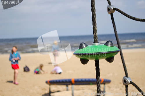 Image of Kids in playground near sea. Climb toys equipment 