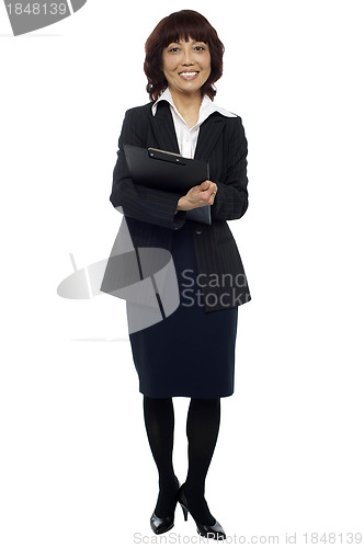 Image of Female secretary holding clipboard, waiting for boss