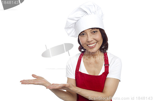 Image of Smiling asian chef gesturing guests to take their seats