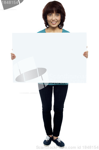 Image of Asian female model cheerfully holding blank billboard