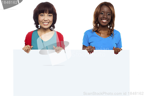 Image of African and Asian marketing personnel holding billboard