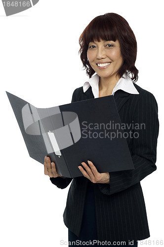 Image of Secretary holding opened binder, smiling