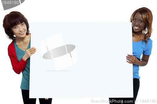 Image of Two ethnic female models presenting whiteboard