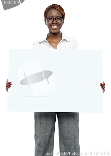 Image of Female business executive holding blank billboard
