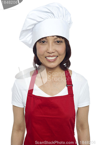 Image of Young smiling female chef wearing red apron