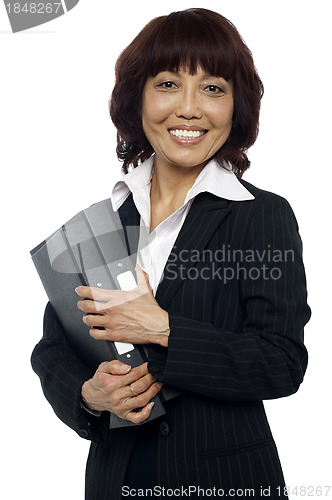 Image of Smiling female executive holding binder