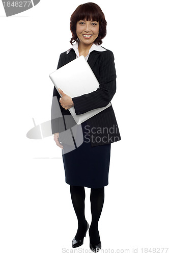 Image of Female executive posing with laptop, full length shot