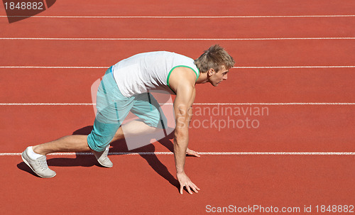 Image of Young man preparing to run