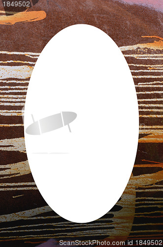 Image of old rusty tin wall detail and white oval in center 