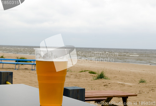 Image of full beer stein mug stand pub table near sea beach 