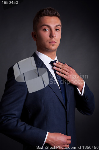 Image of young businessman adjusting his tie 