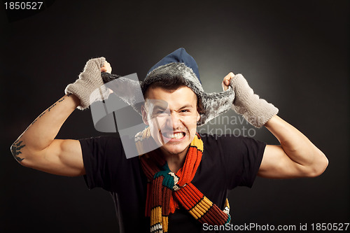 Image of  man pulling on his fur winter hat