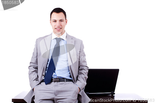 Image of  businessman sitting against desk