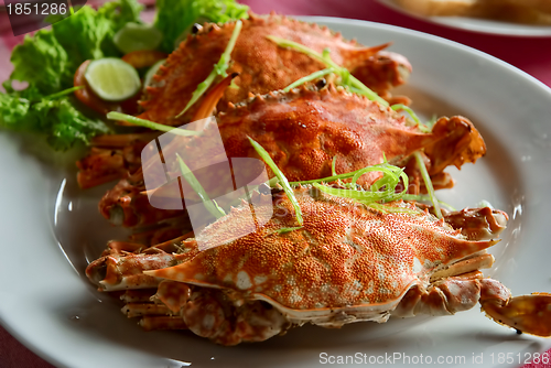 Image of three large red crabs with salad and lime