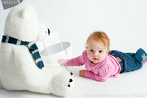 Image of Baby girl with bear toy