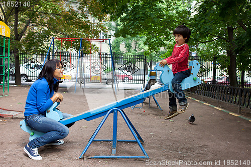 Image of woman with a boy on a swing