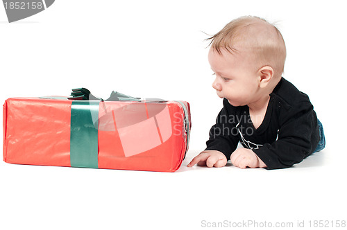 Image of Beautiful baby boy watching on christmas present