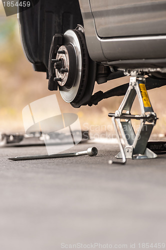 Image of Car without tire on the road