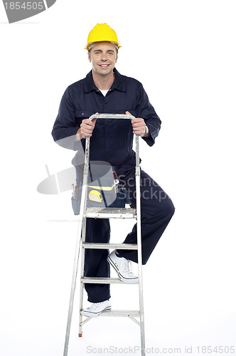 Image of Its work time. Repairman climbing stepladder