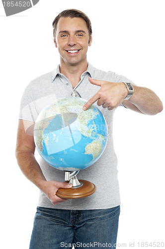 Image of Isolated young man pointing at globe