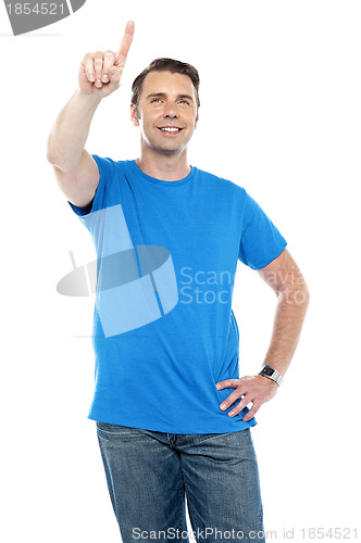 Image of Young smiling male pointing up the copy space