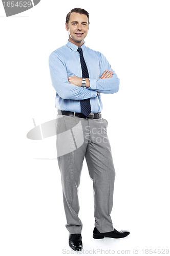 Image of Young team leader smiling confidently with his arms crossed