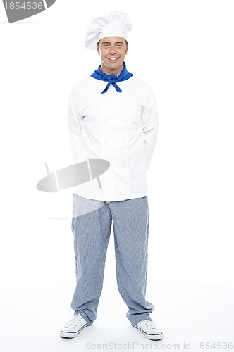 Image of Smart young smiling male chef posing casually