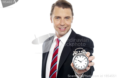 Image of Smiling young consultant showing alarm clock