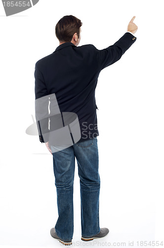 Image of Back pose casual guy pointing at the copy space area